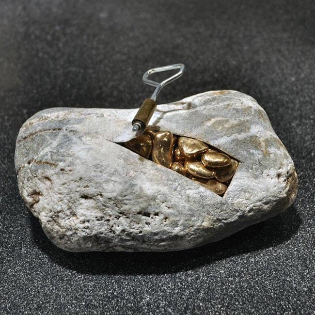 Scultura realistica: pietra con dei sassi dorati