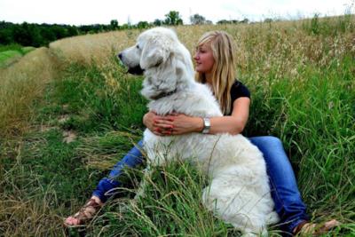 Una donna e il suo cane seduti su un prato