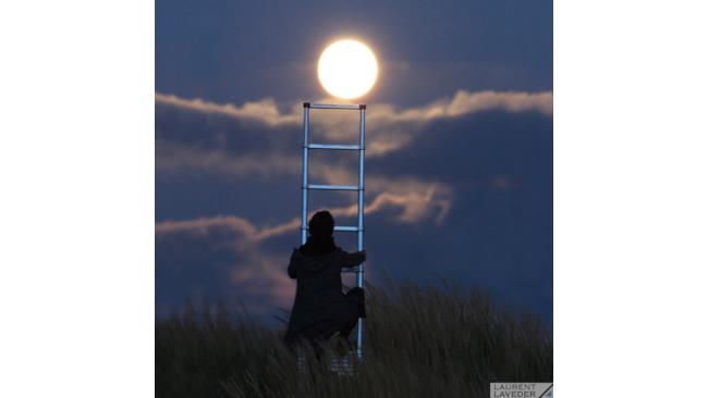 una persona cerca di raggiungere la Luna con una scala