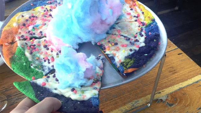 Pizza Unicorno Una donna tiene in mano una Pizza Unicorno