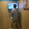 Un uomo intento a urinare mentre guarda la tv