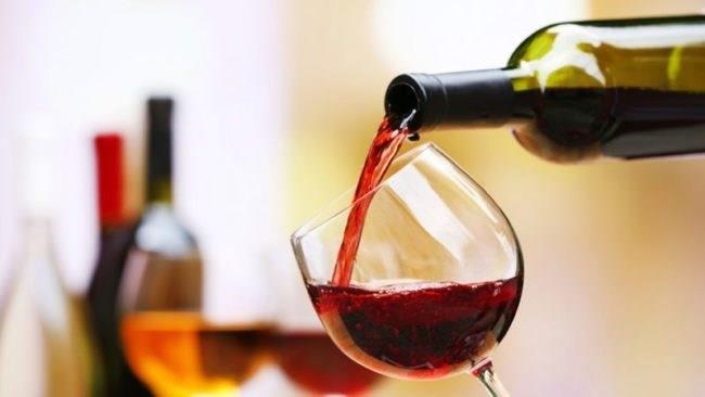 Un bicchiere di vino rosso Una bottiglia da cui sgorga del vino rosso.