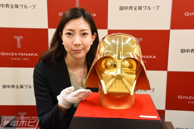 una ragazza vicino al casco d'oro di Darth Vader