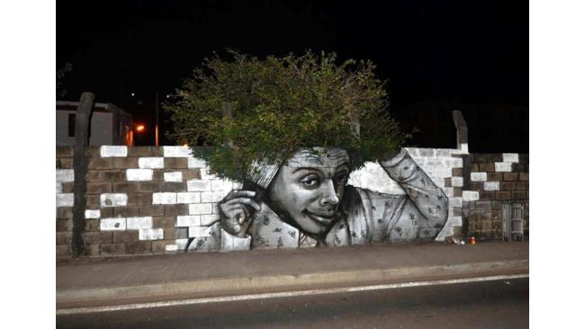 Street art: uomo disegnato con capelli di foglie