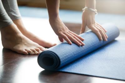 Una donna si appresta a esercitarsi sul tappetino da yoga