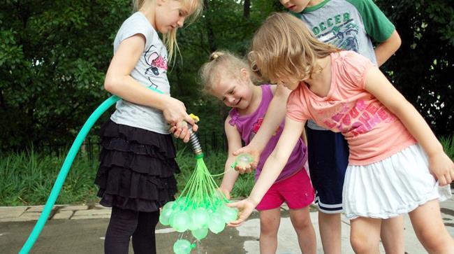 Invenzione per cui si possono riempire d'acqua 37 palloncini alla volta Bambini che riempono palloncini d'acqua con un'invenzione che ne può riempire 100 in meno di un minu