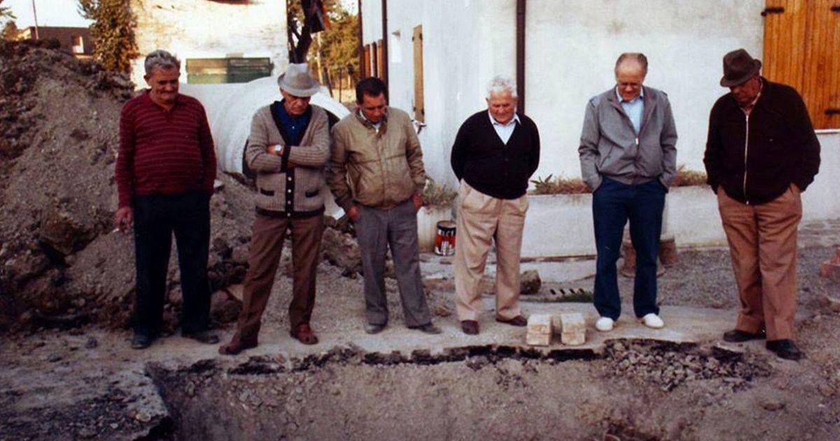 Un gruppo di anziani guarda un cantiere