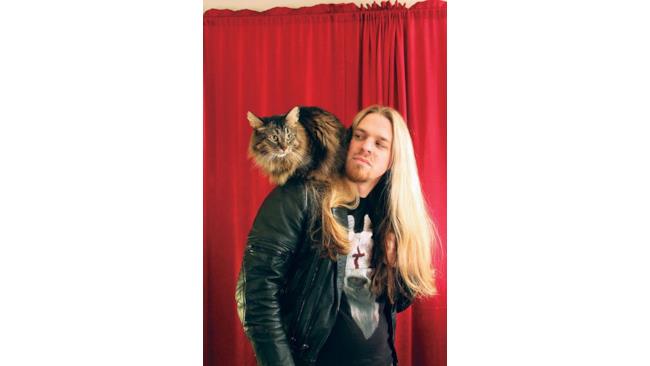 Un uomo con una chioma stupenda con un gatto dal pelo stupendo
