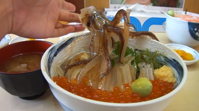 Calamari che ballano nel piatto Calamari che danzano nella ciotola stimolati dalla salsa di soja