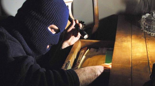 Australiano organizza una rapina in casa per lasciare la sua ragazza Un rapinatore fruga un cassetto