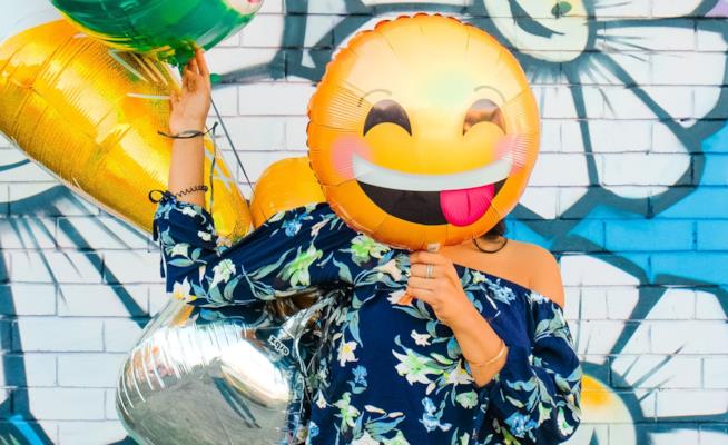 Una donna con un palloncino a forma di emoji sorridente L’abilità in cucina si apprende Vestire bene e’ questione di soldi Lui deve mantenere nel tempo la p