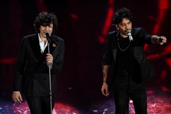 Ermal Meta e Fabrizio Moro canteranno Non mi avete fatto niente Ermal Meta e Fabrizio Moro, in piedi, di fronte a un microfono, vestiti di nero, con sfondo rosso