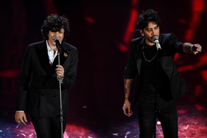 Ermal Meta e Fabrizio Moro canteranno Non mi avete fatto niente Ermal Meta e Fabrizio Moro, in piedi, di fronte a un microfono, vestiti di nero, con sfondo rosso