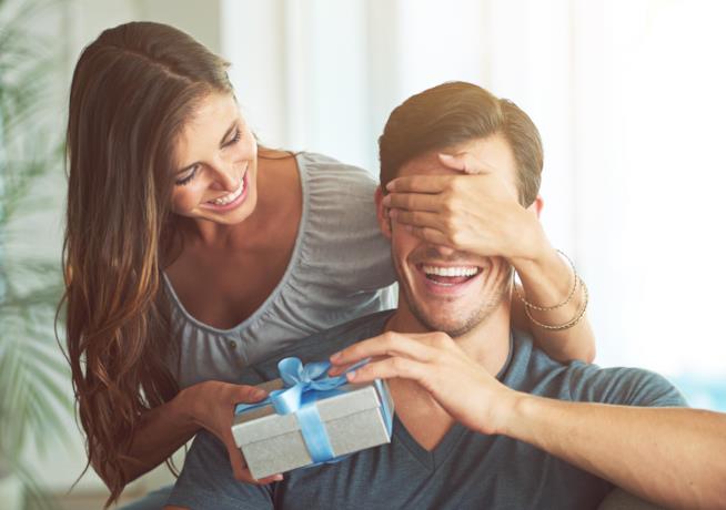Regali di San Valentino per lui Una ragazza consegna un regalo ad un ragazzo
