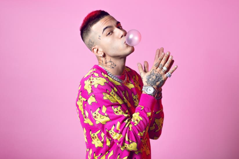 Sfera Ebbasta a Radio Italia Live Sfera Ebbasta, con una maglia raffigurante Pikachu, su sfondo rosa e una big bubble in bocca