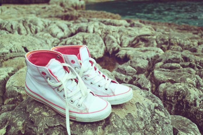 Converse sugli scogli Un paio di Converse in riva al mare