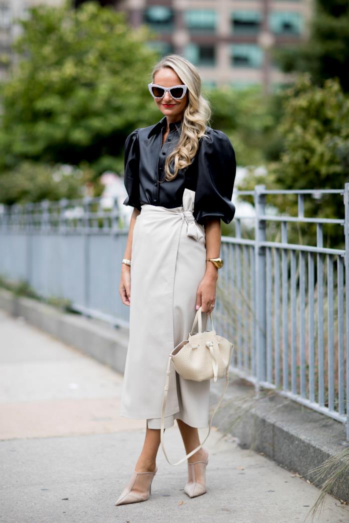Blusa di pelle indossata con gonna midi a portafoglio e pumps con il tacco Blusa di pelle abbinata a gonna midi a portafoglio e pumps con il tacco