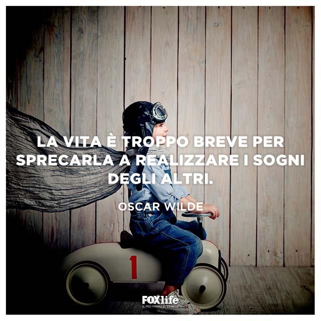 Citazione Wilde Bambino vestito da supereroe su una motoretta giocattolo