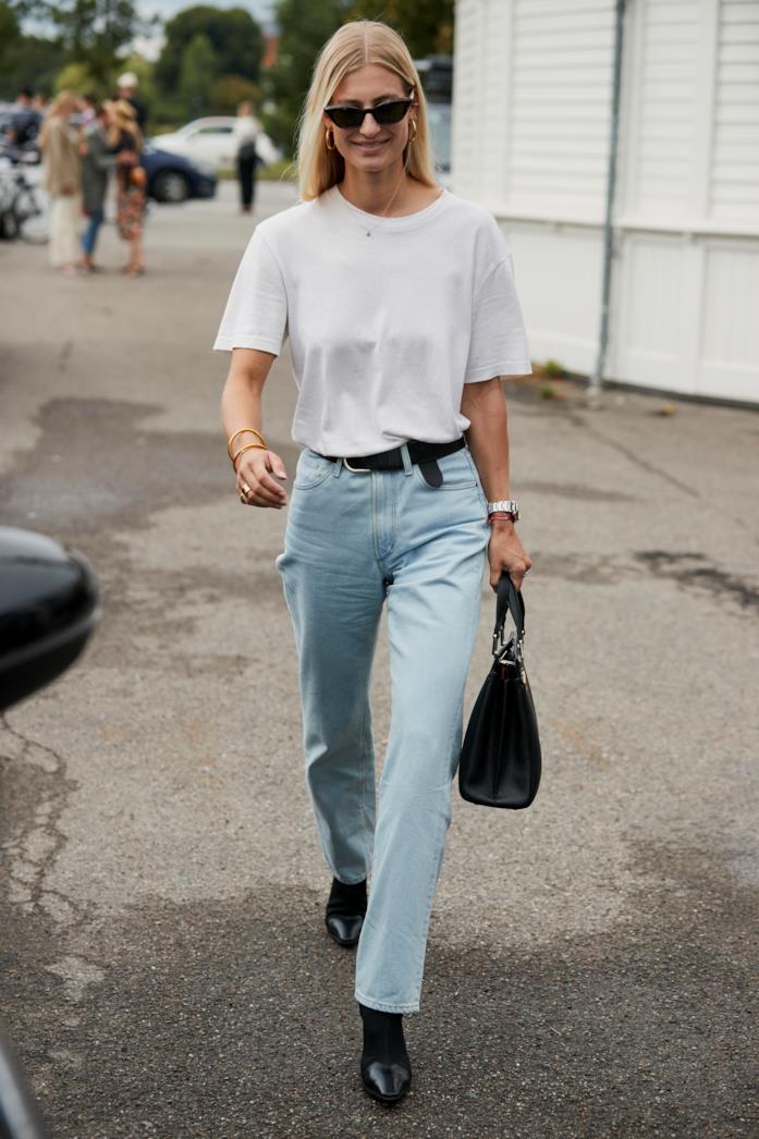 T-shirt bianca indossata con jeans e stivaletti T-shirt bianca abbinata a jeans e stivaletti