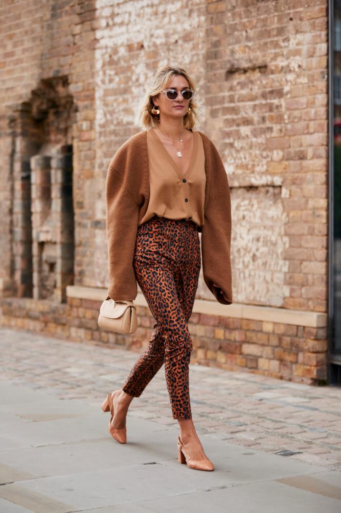Pantaloni leopardati indossati con camicetta beige e décolleté Pantaloni leopardati abbinati a camicetta beige e décolleté
