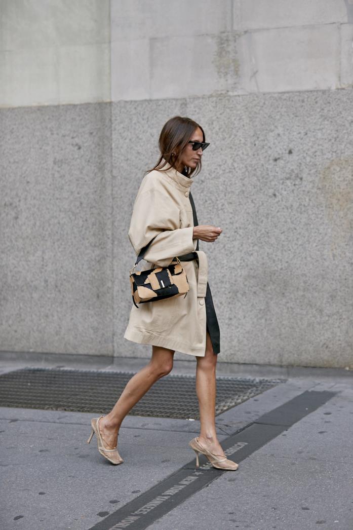 Trench con cintura in vita indossato con scarpe a rete e borsa a spalla Trench con cintura in vita abbinato a scarpe a rete e borsa a spalla