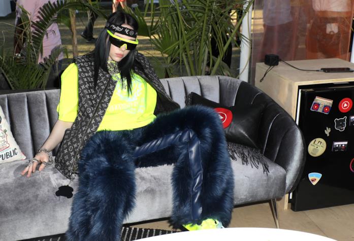 Billie Eilish Billie Eilish in pantaloni di pelliccia, t-shirt e sneakers fluo e gilet di pelle Vuitton