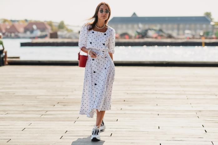 Abito midi a pois e sneakers Sneakers bianche indossate con un abito midi