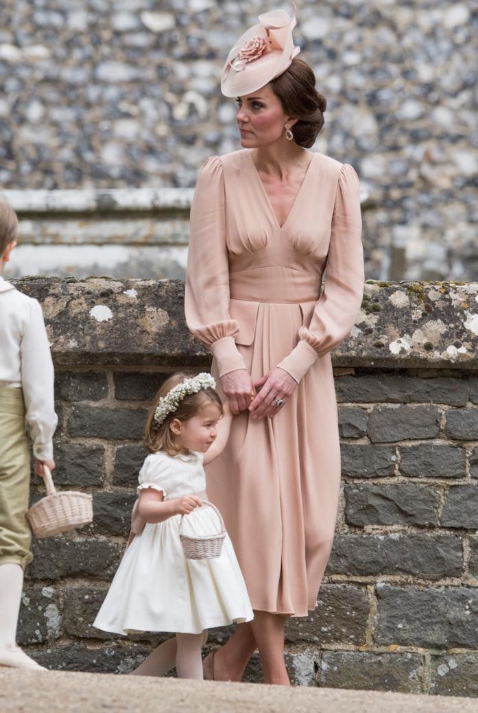 Un abito rosa sotto il ginocchio con cappellino coordinato Un abito rosa a maniche lunghe molto chic
