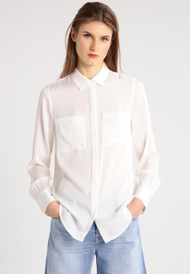 I capi che tutte le donne dovrebbero avere nell'armadio Donna che indossa la camicia bianca