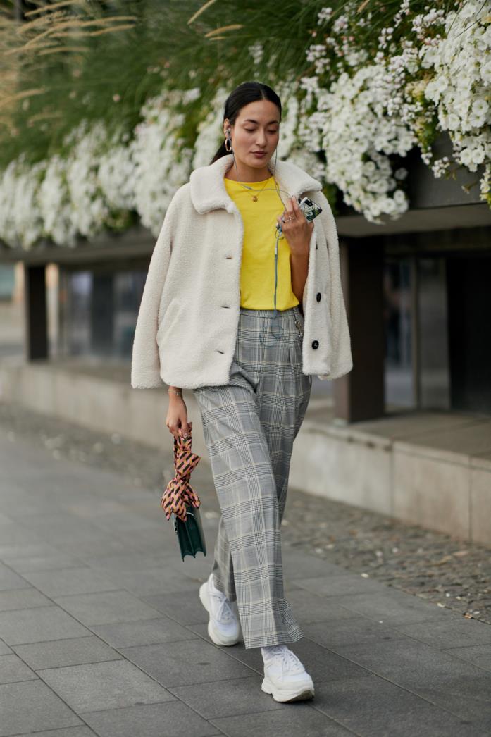 Pantaloni a quadri indossati con t-shirt e sneakers Pantaloni a quadri abbinati a t-shirt e sneakers