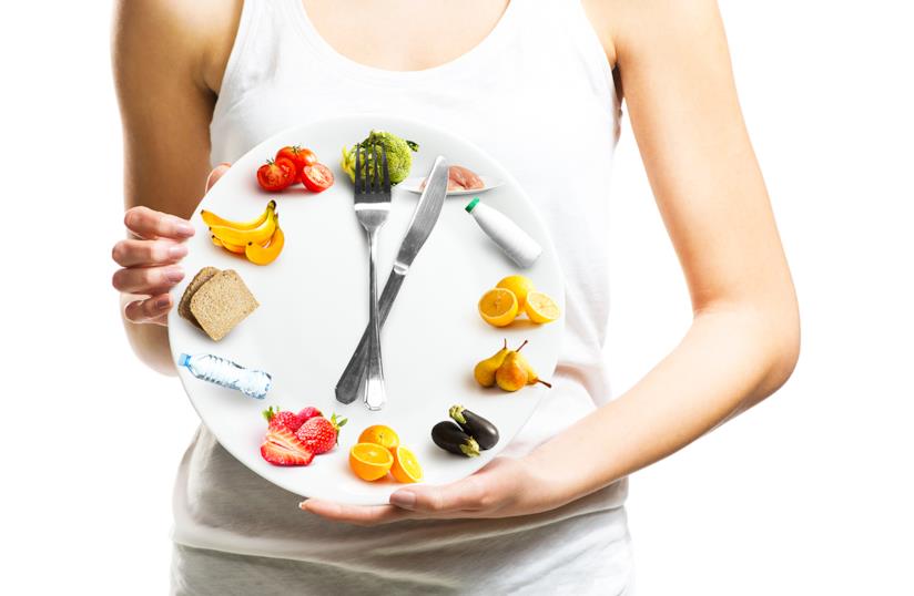 Vitamine e nutrienti dopo i 40 anni Donna con un orologio con disegnati alimenti