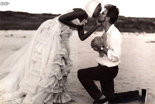David Bowie e Iman sposi David Bowie è in spiaggia in ginocchio davanti a Iman, in abito da sposa
