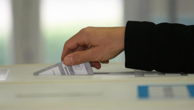 Elezioni politiche 2018 Una persona consegna la sua scheda elettorale