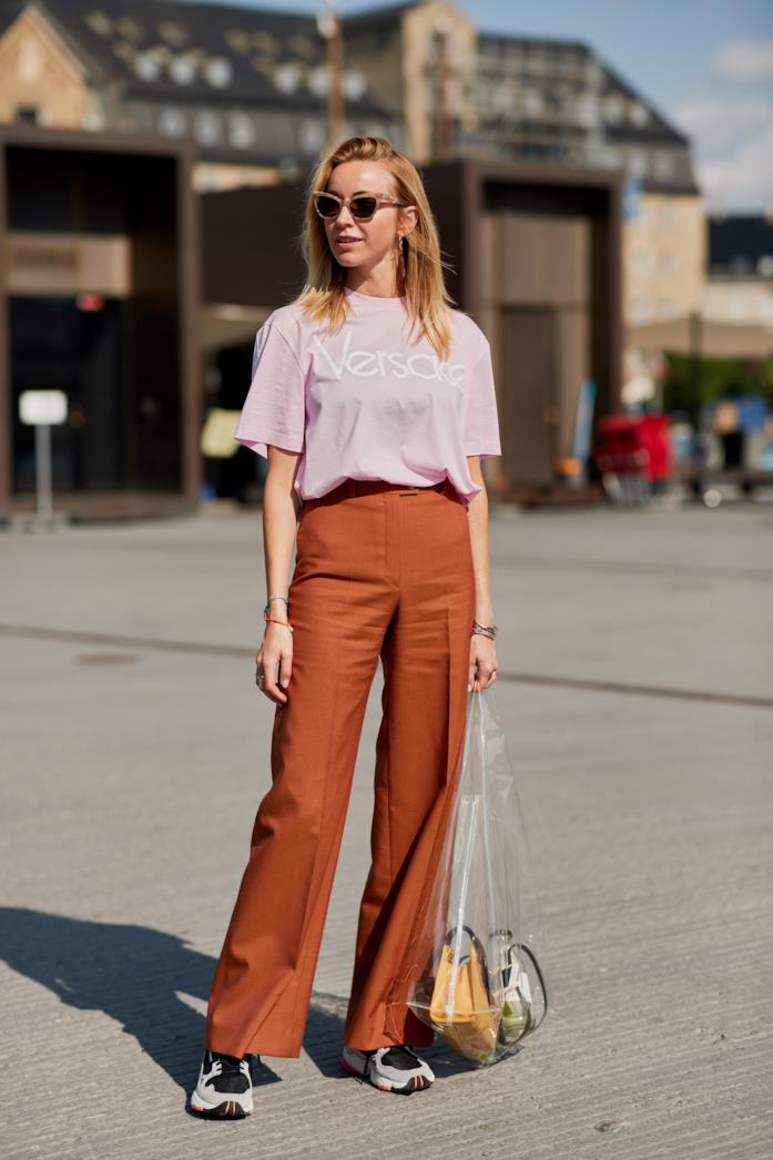 Sneakers abbinate a t-shirt grafica e pantaloni larghi Sneakers indossate con pantaloni e t-shirt sportiva
