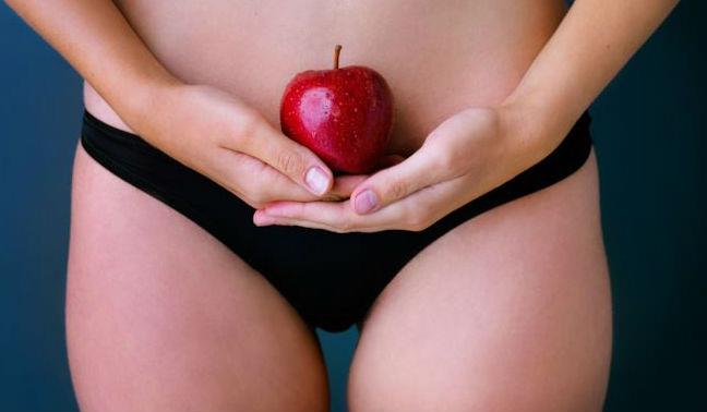 Come richiedere l'esenzione dall'endometriosi Donna che tiene una mela vicino al ventre