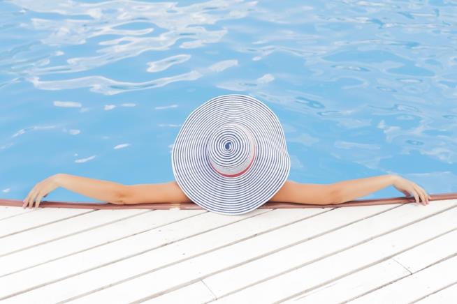 Combattere lo stress e allontanare le tensioni: i rimedi più efficaci. Una donna di spalle mentre è in piscina.