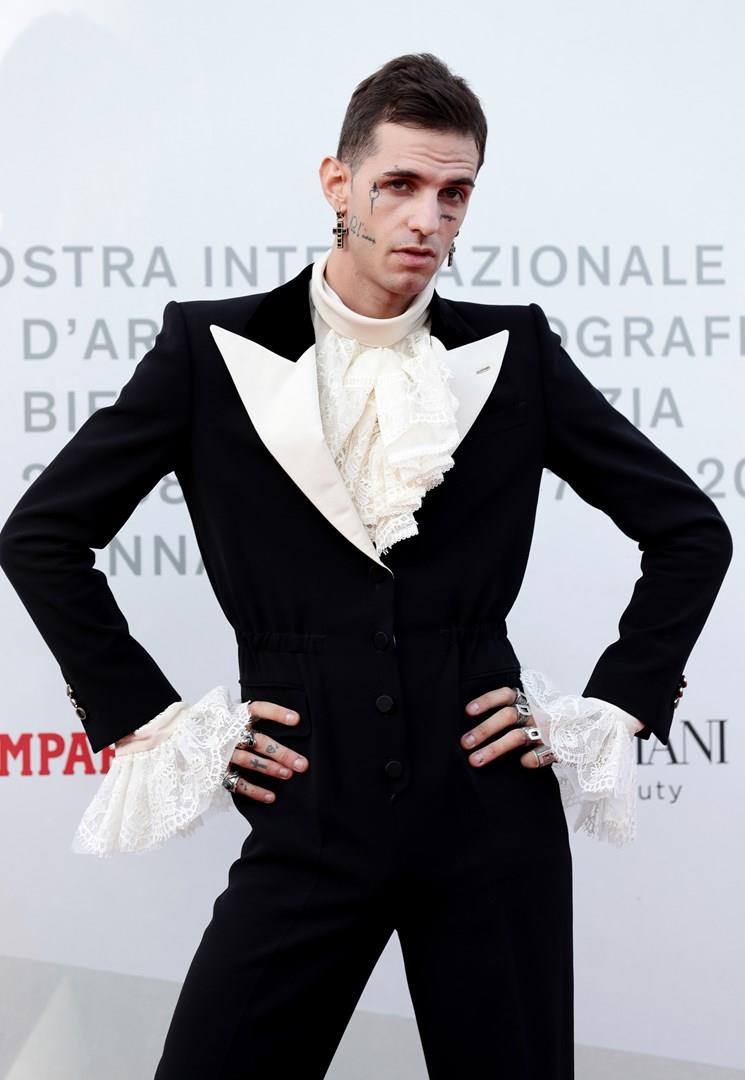 Achille Lauro Achille Lauro, in piedi, con un abito nero e una camicia bianca