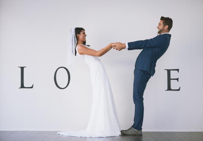 Il matrimonio rappresenta un traguardo quando si basa sull'amore vero e sul rispetto reciproco. Due sposi che formano la scritta love.
