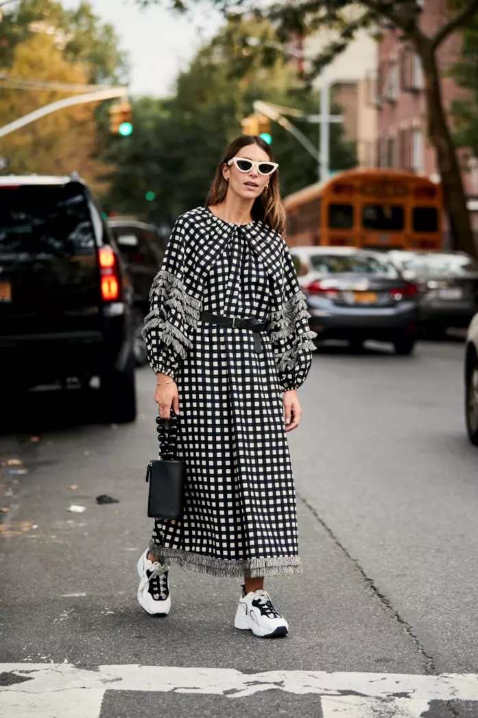 Abito lungo a quadretti indossato con sneakers sportive e handbag Maxi dress a stampa vichy abbinato a sneakers e mini handbag
