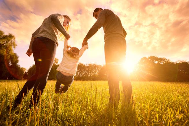 Il rapporto tra genitori e figli è spesso centrale nelle serie televisive Mamma e papà portano per mano il figlio in un prato