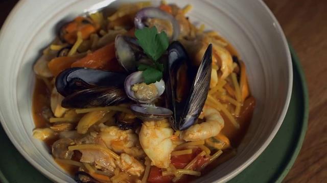 Fideuà con spaghetti spezzati, cozze, vongole, gamberi, seppie e scorfano Fideuà