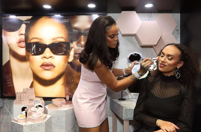 Rihanna debutta nella skincare Rihanna mentre trucca una ragazza