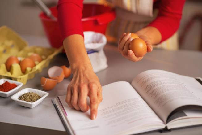I libri che non possono mancare nella biblioteca di chi ama la cucina Consultare un libro mentre si cucina