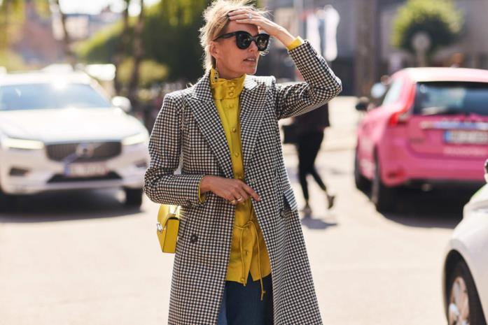 Blusa dai colori vivaci abbinata a trench stampato Un trench a stampa vichy abbinato a blusa e tracolla gialle
