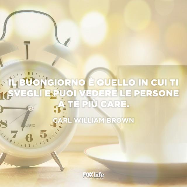 Citazione Brown Sveglia vicino a una tazza di cappuccino