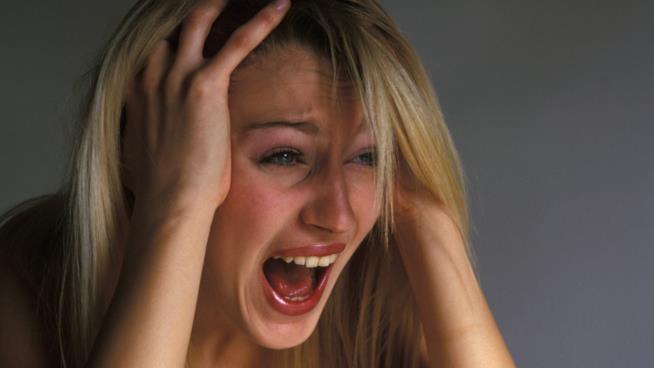 Riconoscere gli attacchi di panico e come curarli Una donna con le mani tra i capelli