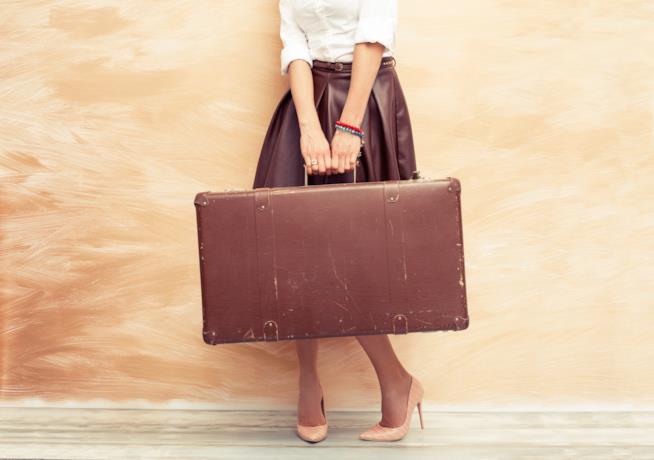 5 tipi di viaggio al femminile Una donna con la valigia
