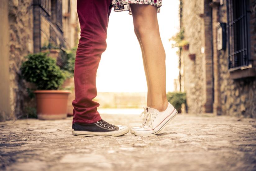 Sedurre il tuo lui in solo cinque mosse gambe e scarpe sportive di un ragazzo e una ragazza, uno di fronte all'altro, lei in punta di piedi