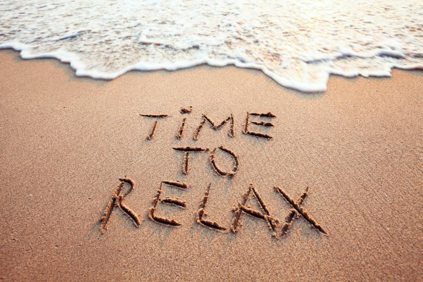 Le mete italiane e i luoghi migliori per rilassarsi nel fine settimana sabbia e un'onda a riva che si avvicina alla scritta time to relax