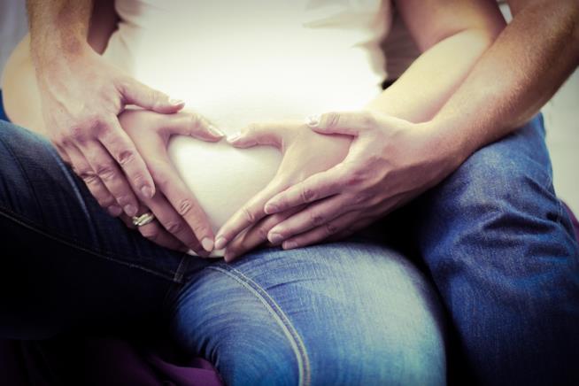 Una coppia in dolce attesa Un uomo abbraccia una donna incinta